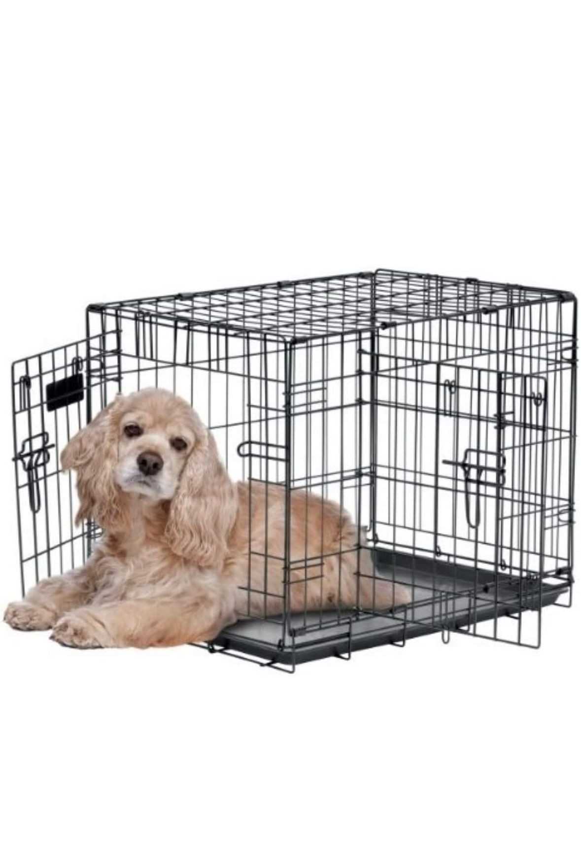 A dog lying inside an open metal crate, resting comfortably on the crate floor.